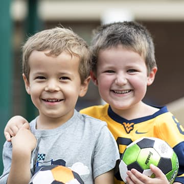 Niños sonrientes con balón de fútbol