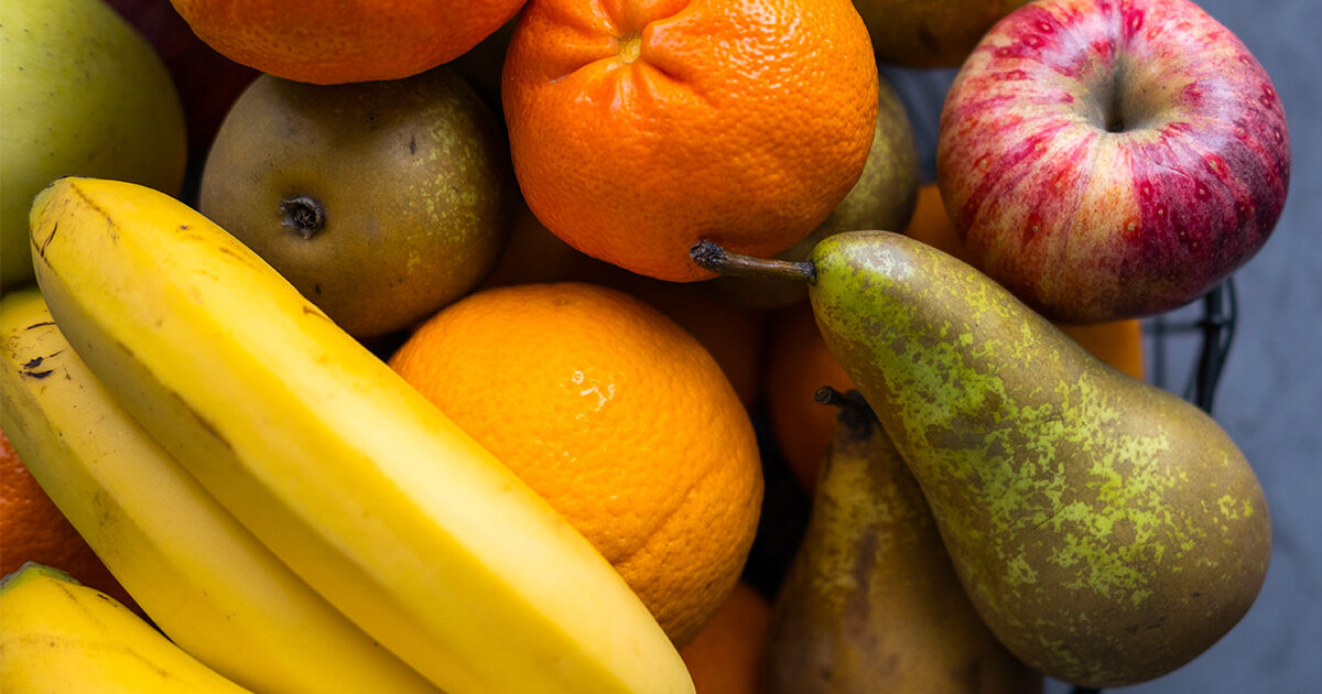 Assorted fresh fruit including bananas, oranges, pears, and an apple.