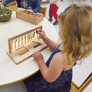 girl playing with Montessori bead toy